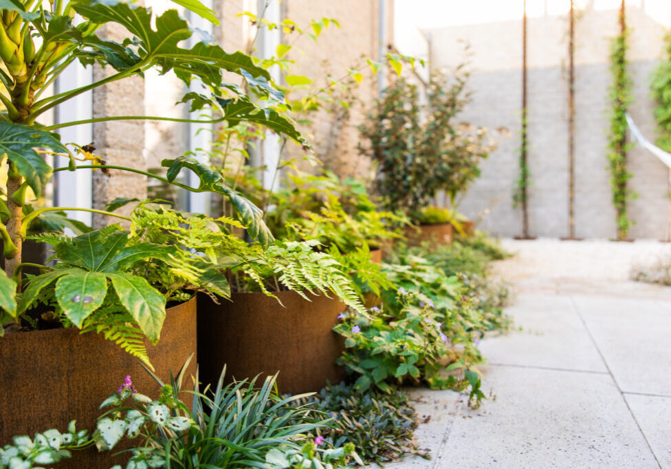 Dorpstuin met diverse materialen en handgemaakte hoekbank - Nuenen